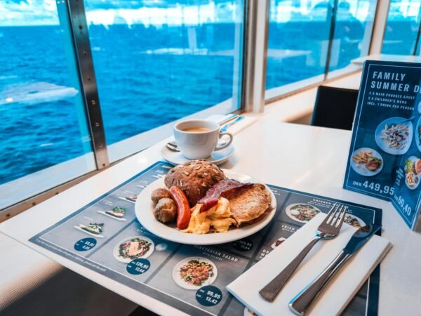 Breakfast setup on a cruise ship with a stunning ocean view through the window.