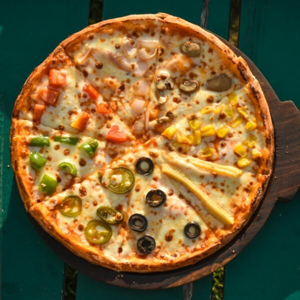 Top view of a variety topping pizza on a wooden board. Perfect for fast food lovers.