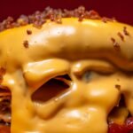 Delicious close-up of a cheeseburger covered in melted cheese, showcasing fast food appeal.