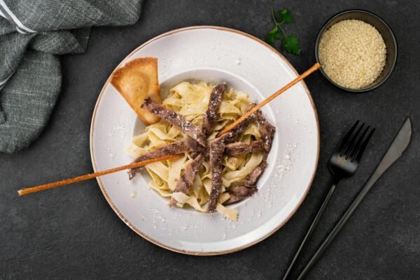 Plate of beef stroganoff with fettuccine pasta, perfect for gourmet dining.