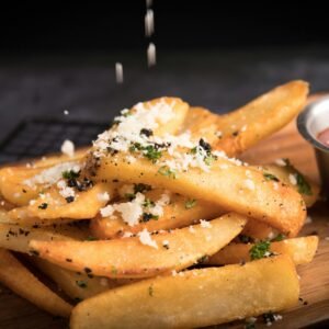 Delicious golden french fries topped with grated cheese and herbs, served with ketchup.