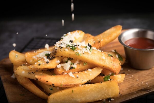 Delicious golden french fries topped with grated cheese and herbs, served with ketchup.