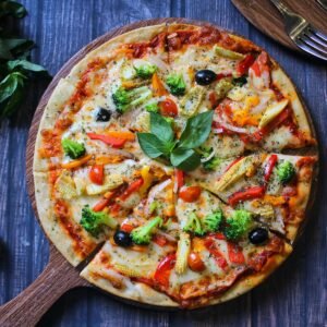 Top view of a colorful vegetarian pizza on a rustic wooden board, perfect for food lovers.