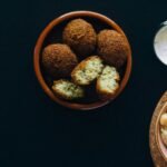 Delicious falafel and creamy hummus served with a side of tzatziki sauce, perfect for vegan meals.